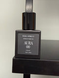 Black perfume bottle labeled  Aura00 by Hall Street  Artisan Parfum on a black surface with a neutral background